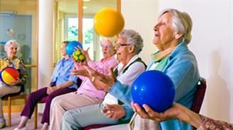 Eine Gruppe älterer Frauen sitzt auf Stühlen und hält Gymnastikbälle in den Händen.