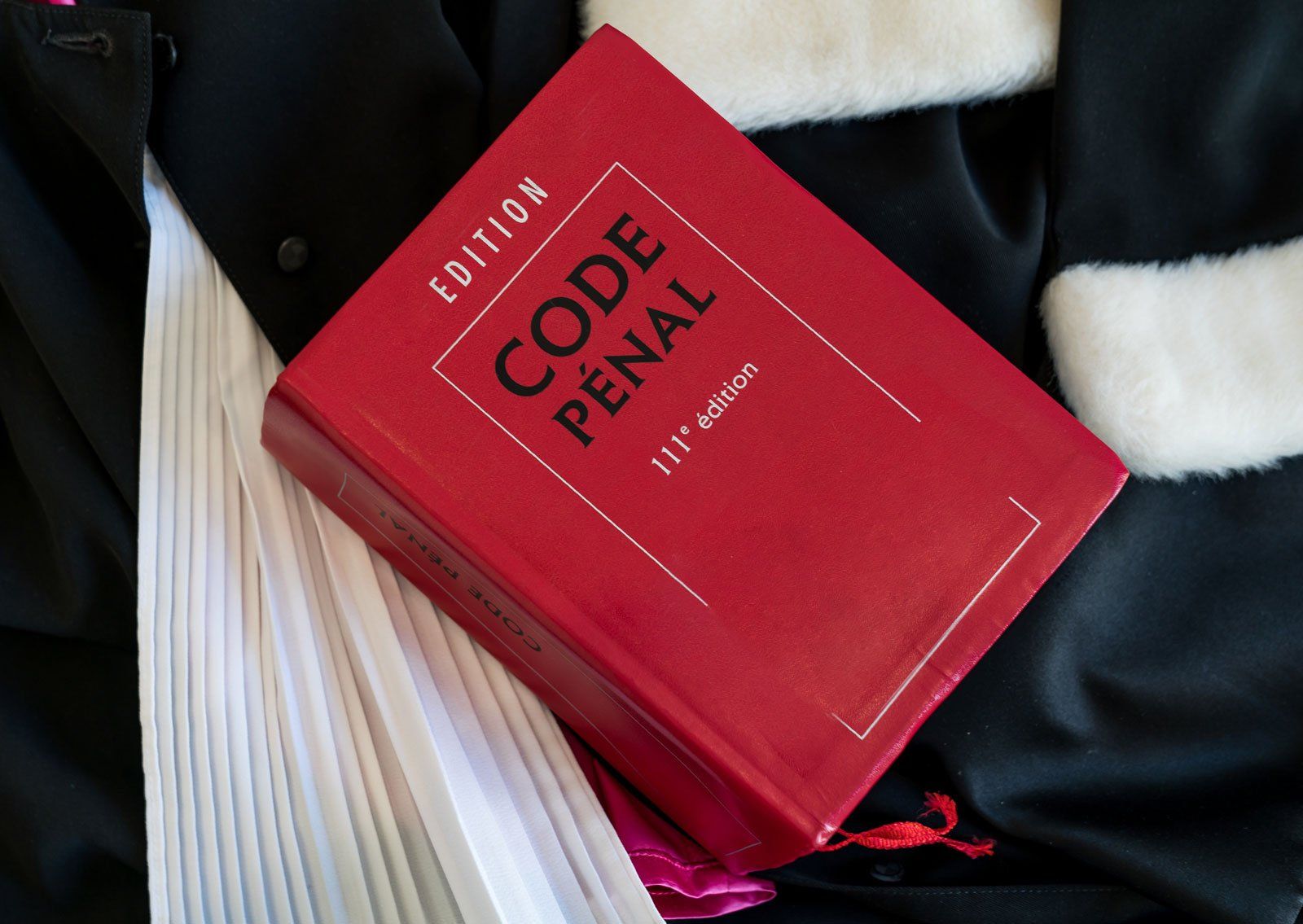 Code pénal posé sur une robe d'avocat