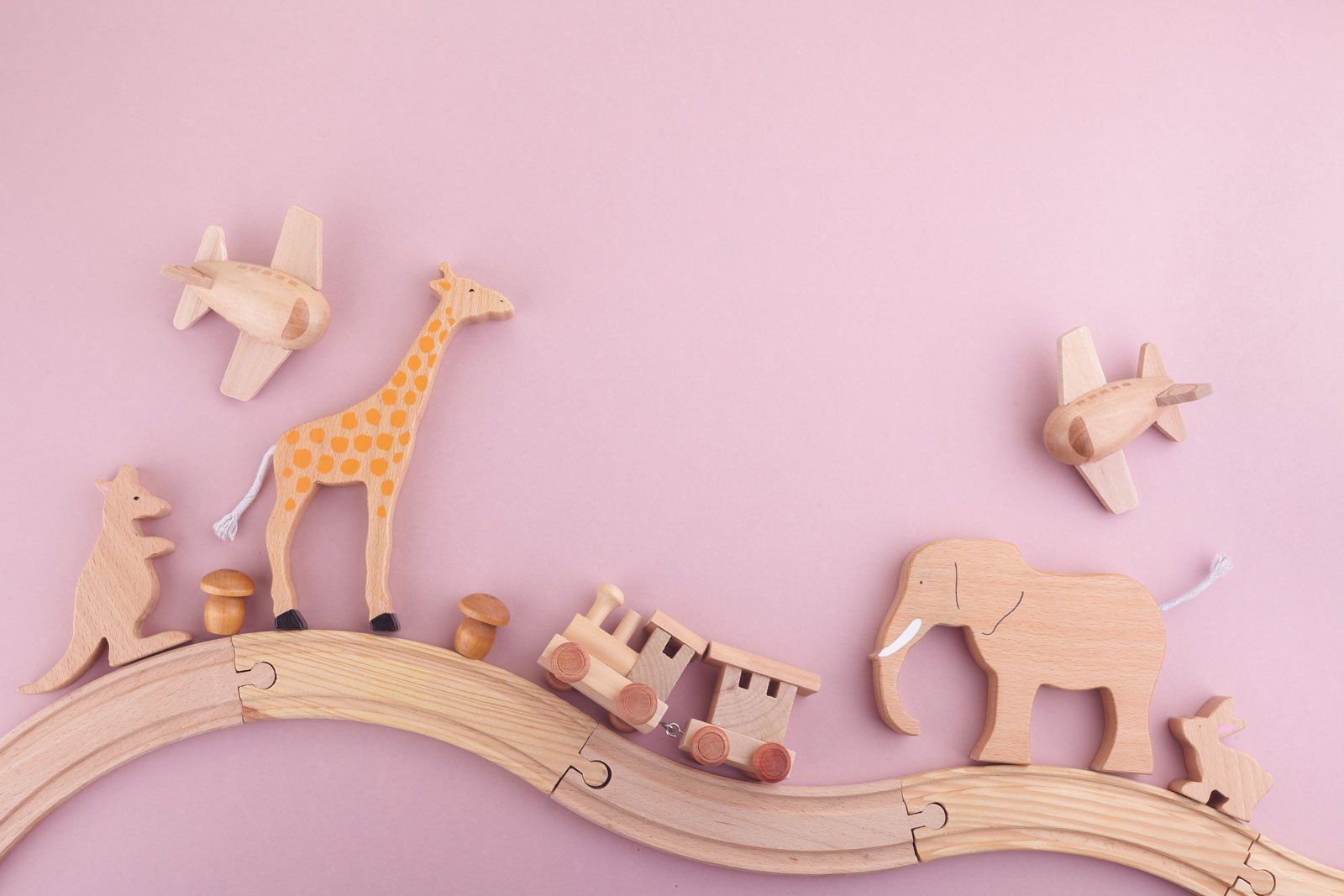 Jouets en bois pour enfant sur fond rose