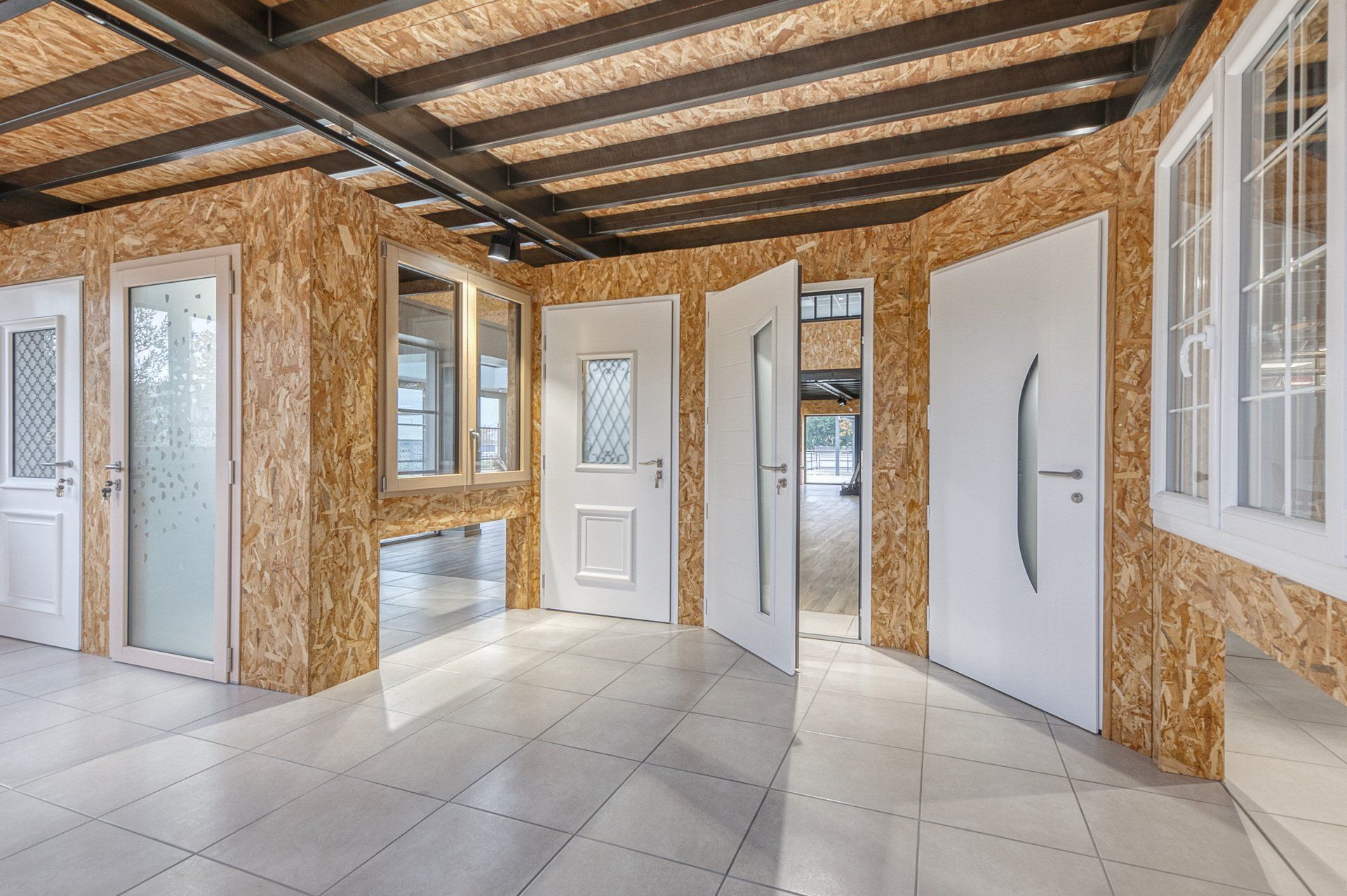 Exposition de portes d'entrées blanches dans un showroom