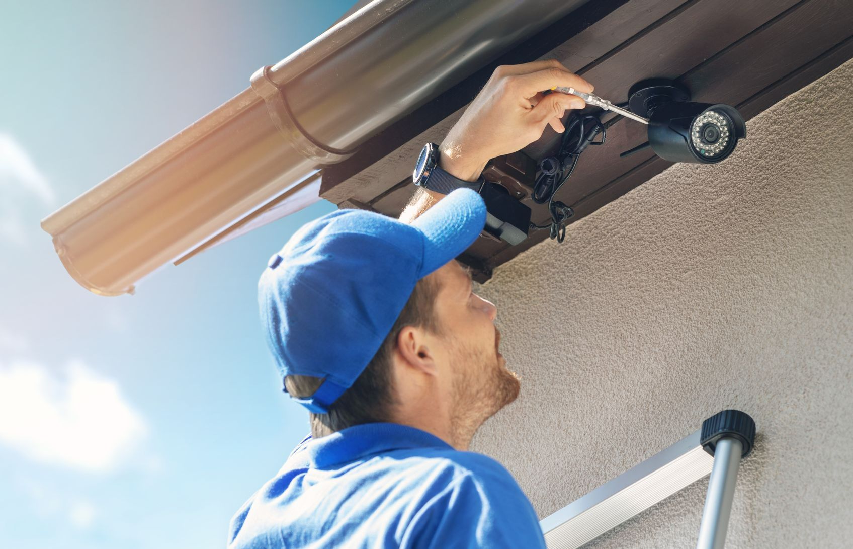Un homme installe une caméra de sécurité