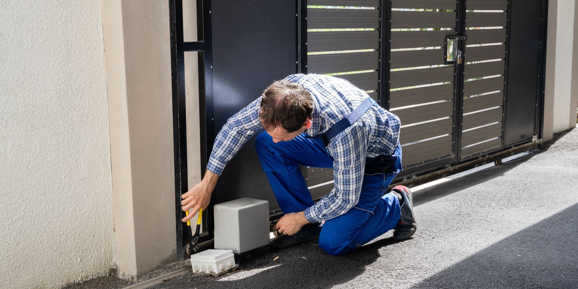T-Un technicien répare un portail automatique