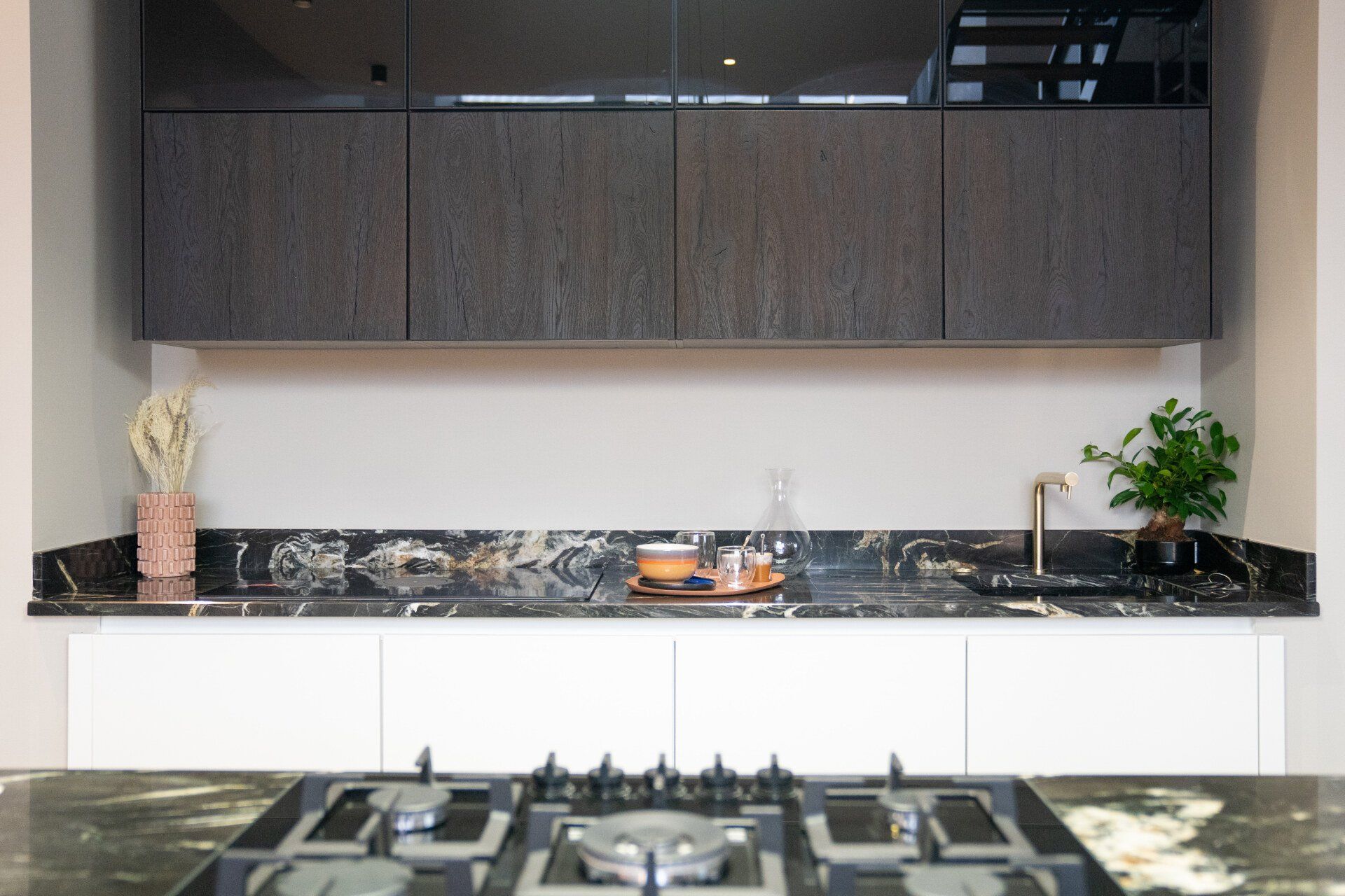 Cuisine avec élément haut en bois foncé et plan de travail en marbre