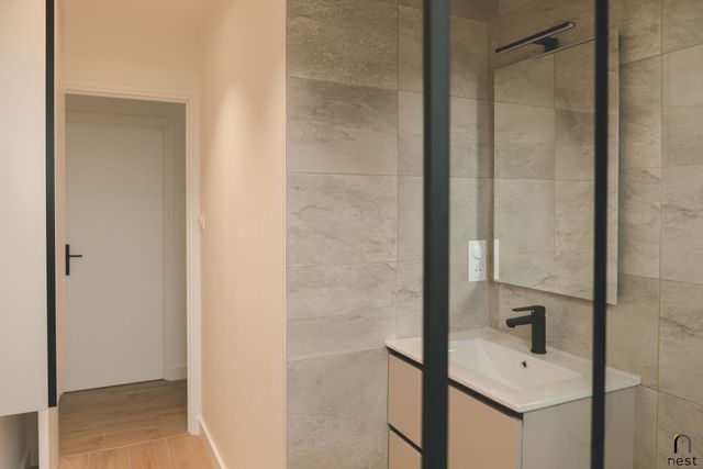 Salle de bains avec paroi de douche et meuble vasque