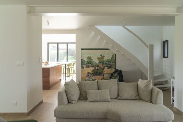 Séjour rénové avec escalier et cuisine ouverte