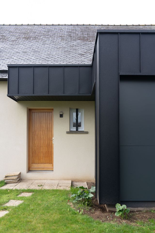Extension en bardage noir et porte d'entrée en bois