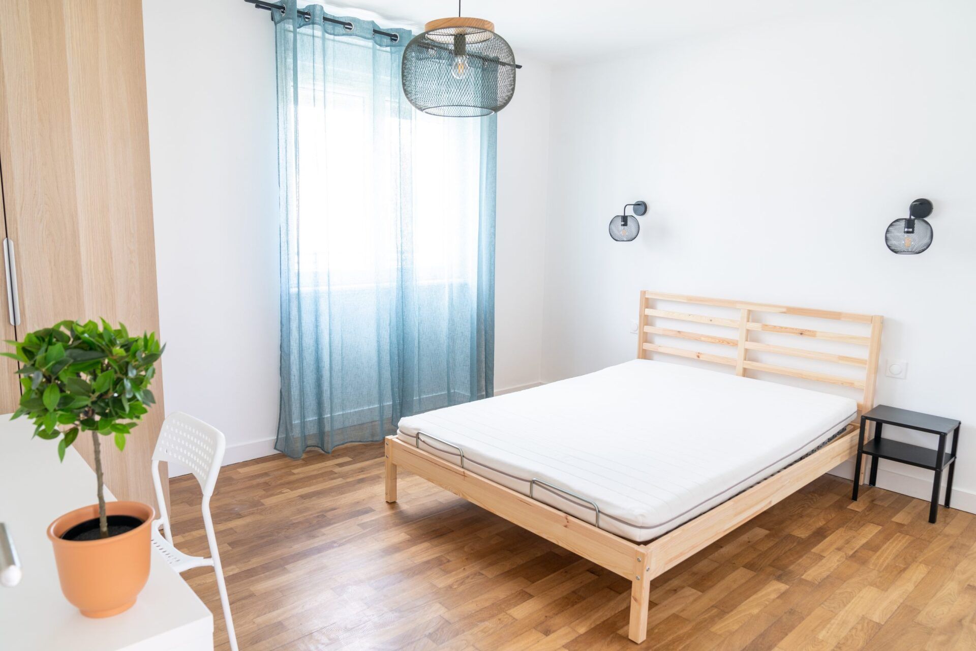 Lit double dans chambre à coucher avec rideaux bleus