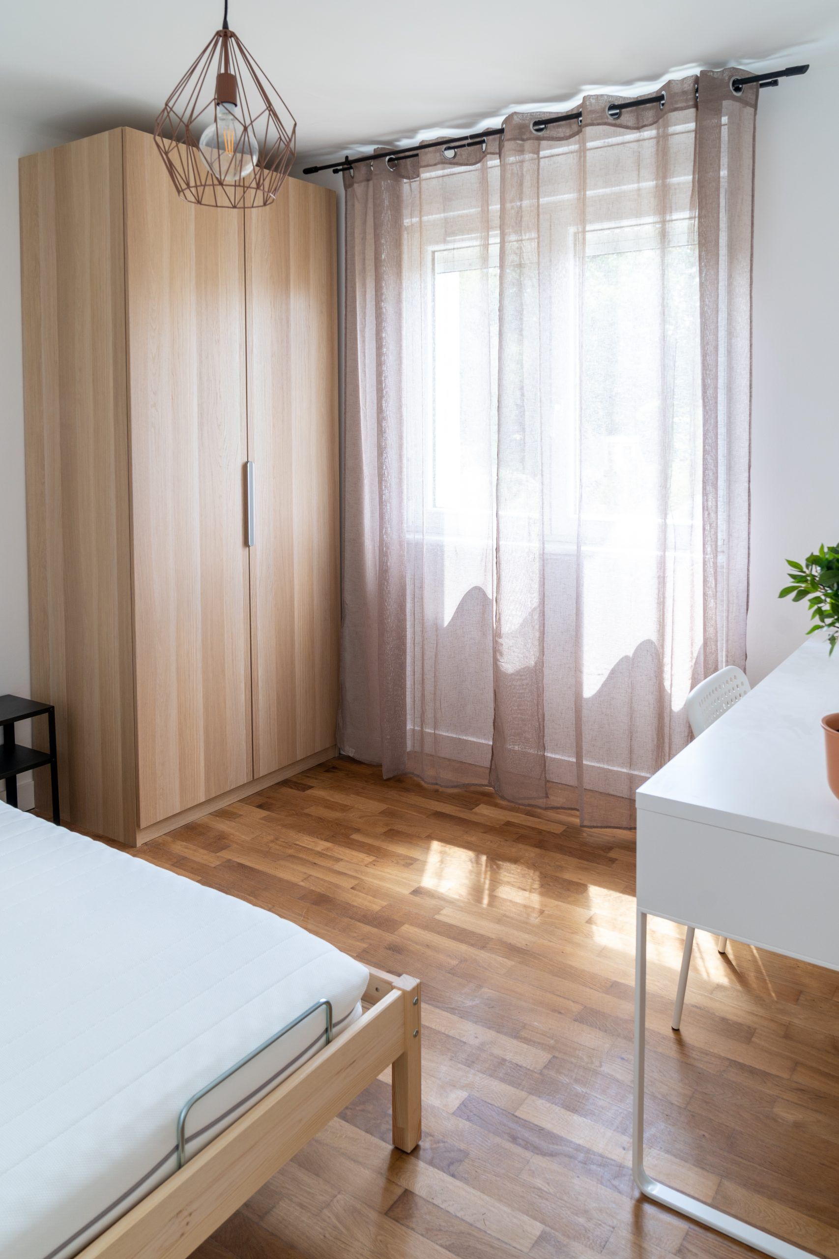 Chambre avec armoire et grande baie vitrée