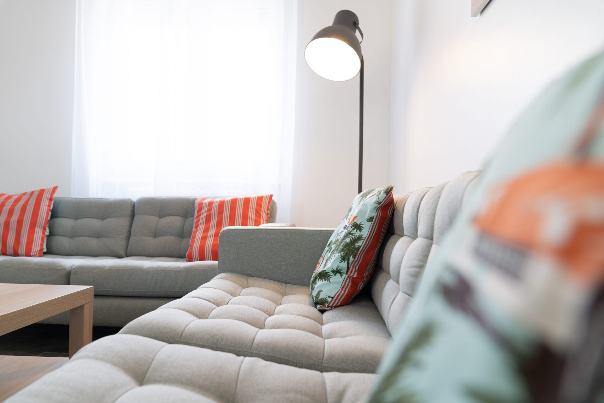 Salon avec canapé gris et coussins colorés