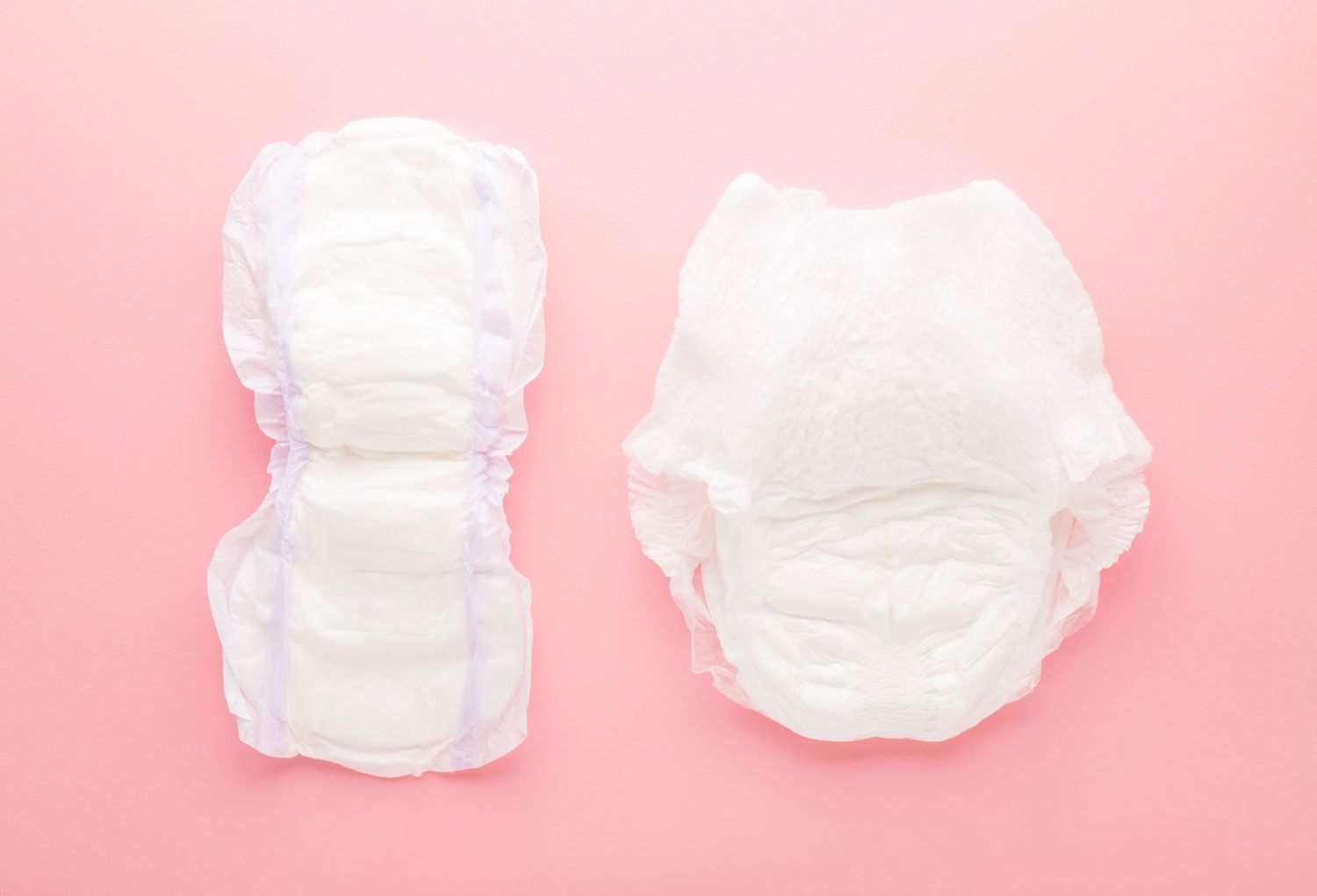 Deux couches blanches pour adultes sur fond rose ; une ouverte, une fermée.
