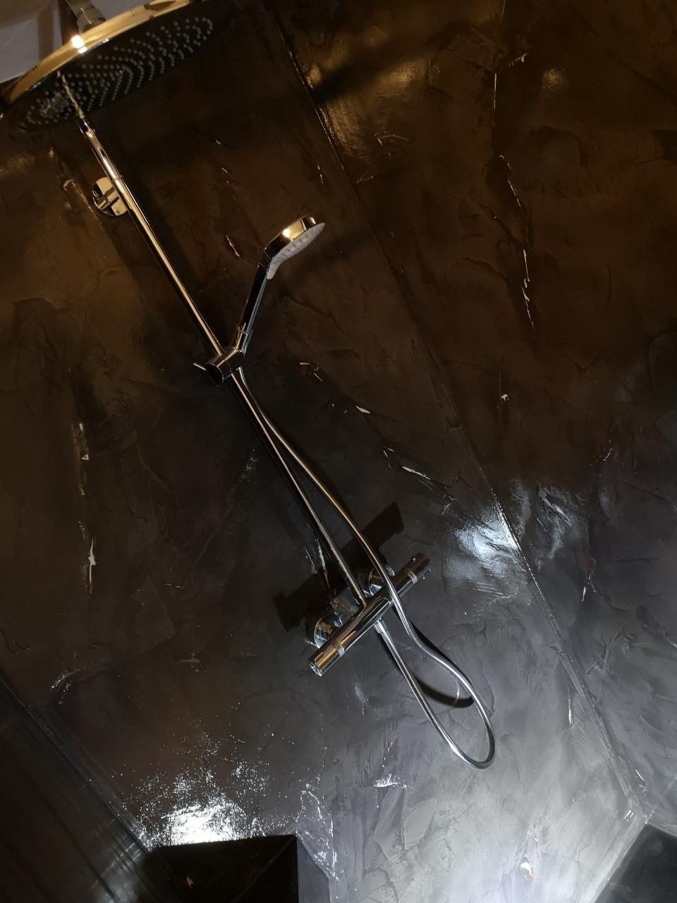 Ein Duschkopf hängt von der Decke in einem dunklen Raum, MALEN TAPEZIEREN JAMES MARTIN