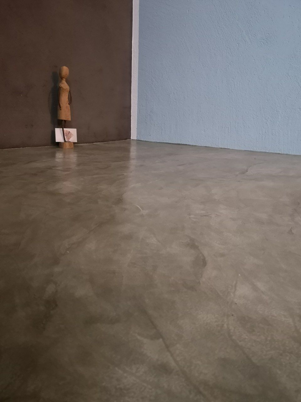 In einem Raum steht eine Frauenstatue auf einem Betonboden. MALEN TAPEZIEREN JAMES MARTIN