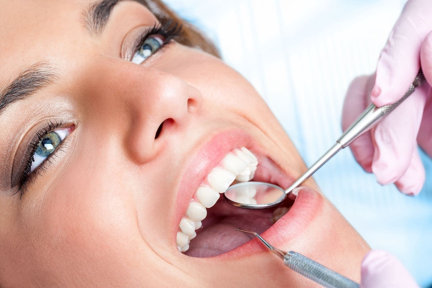 Una mujer está siendo examinada por un dentista.