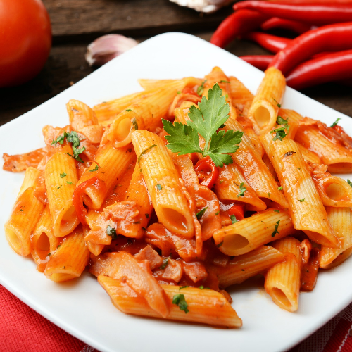 Ein weißer Teller mit Nudeln und Tomatensauce