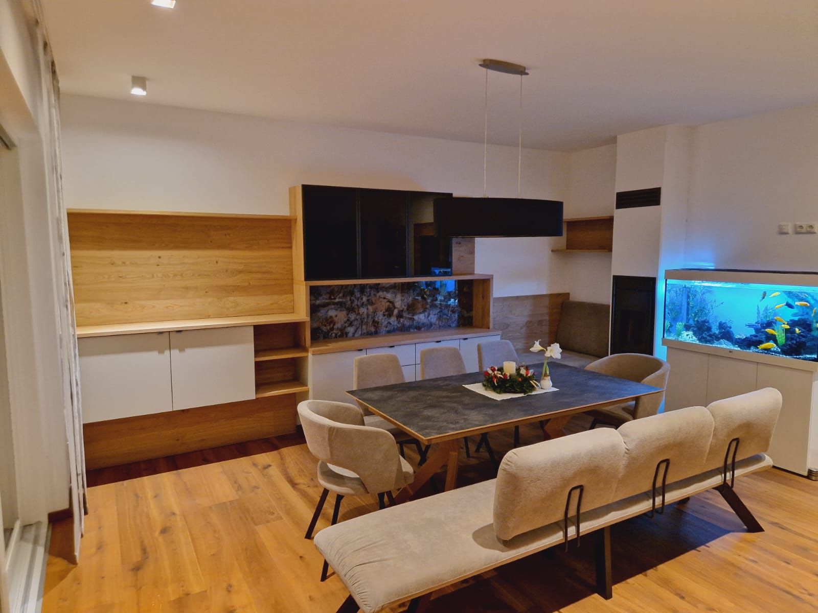 Ein Esszimmer mit Tisch und Stühlen und einem Aquarium.