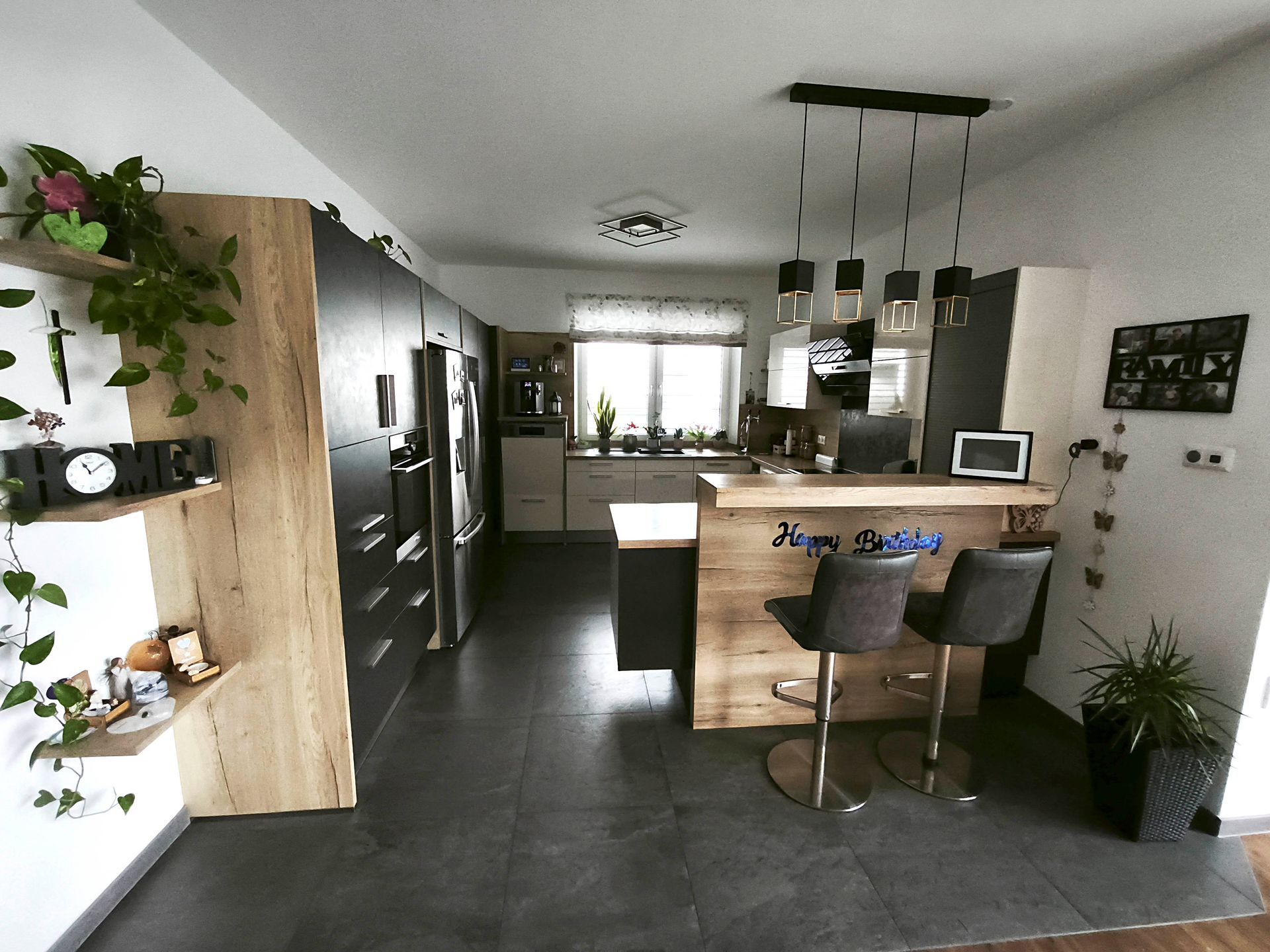 Eine Küche mit Bar und Hockern und einer Uhr an der Wand