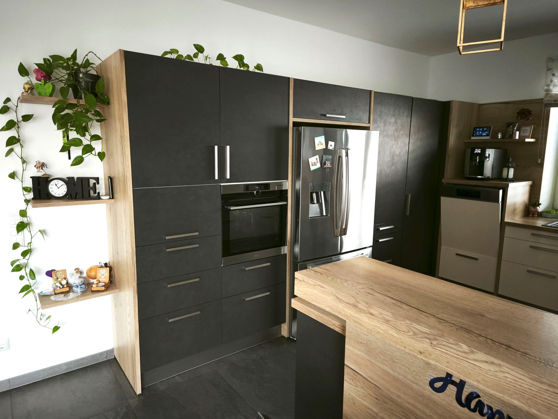 Eine Küche mit schwarzen Schränken und einer Holzarbeitsplatte