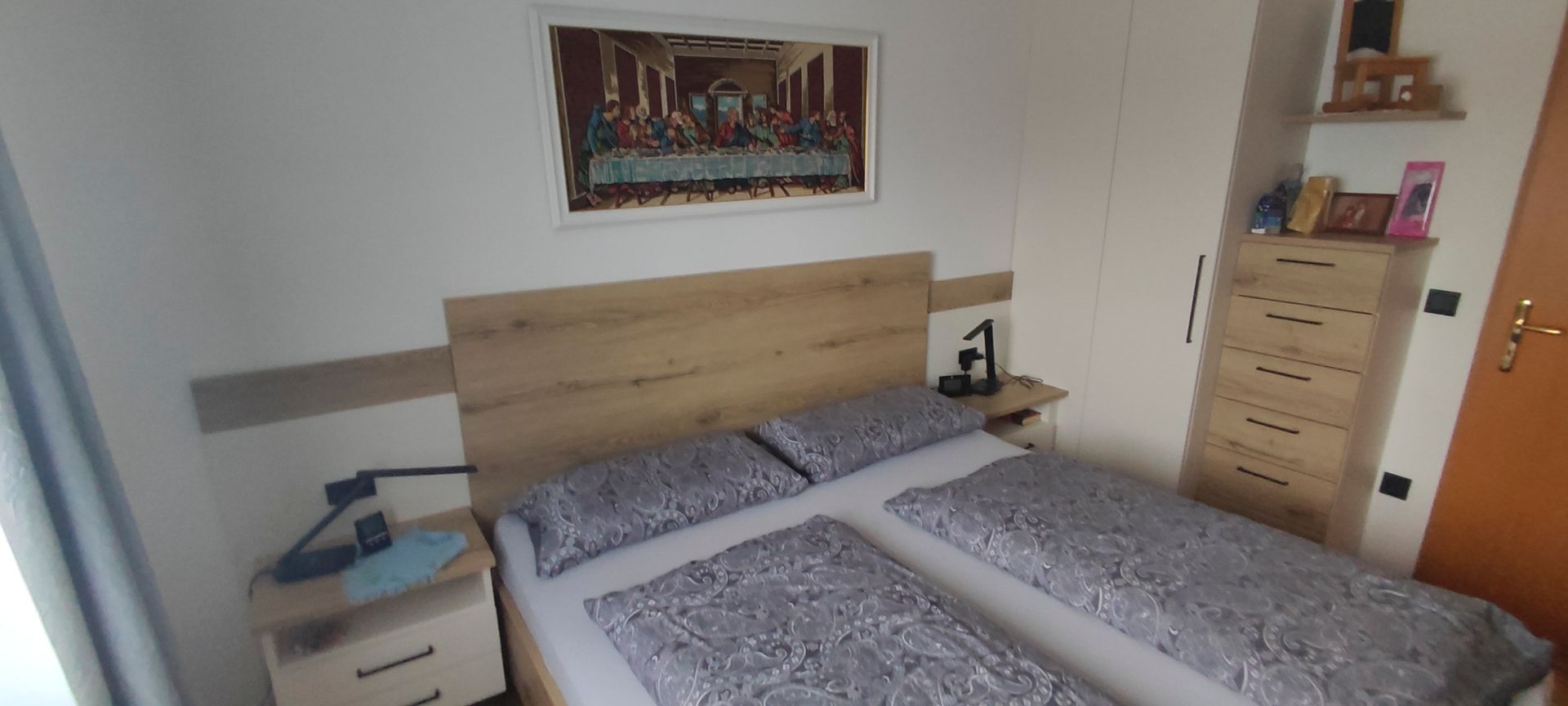 An der Wand über dem Bett im Schlafzimmer hängt ein Gemälde.