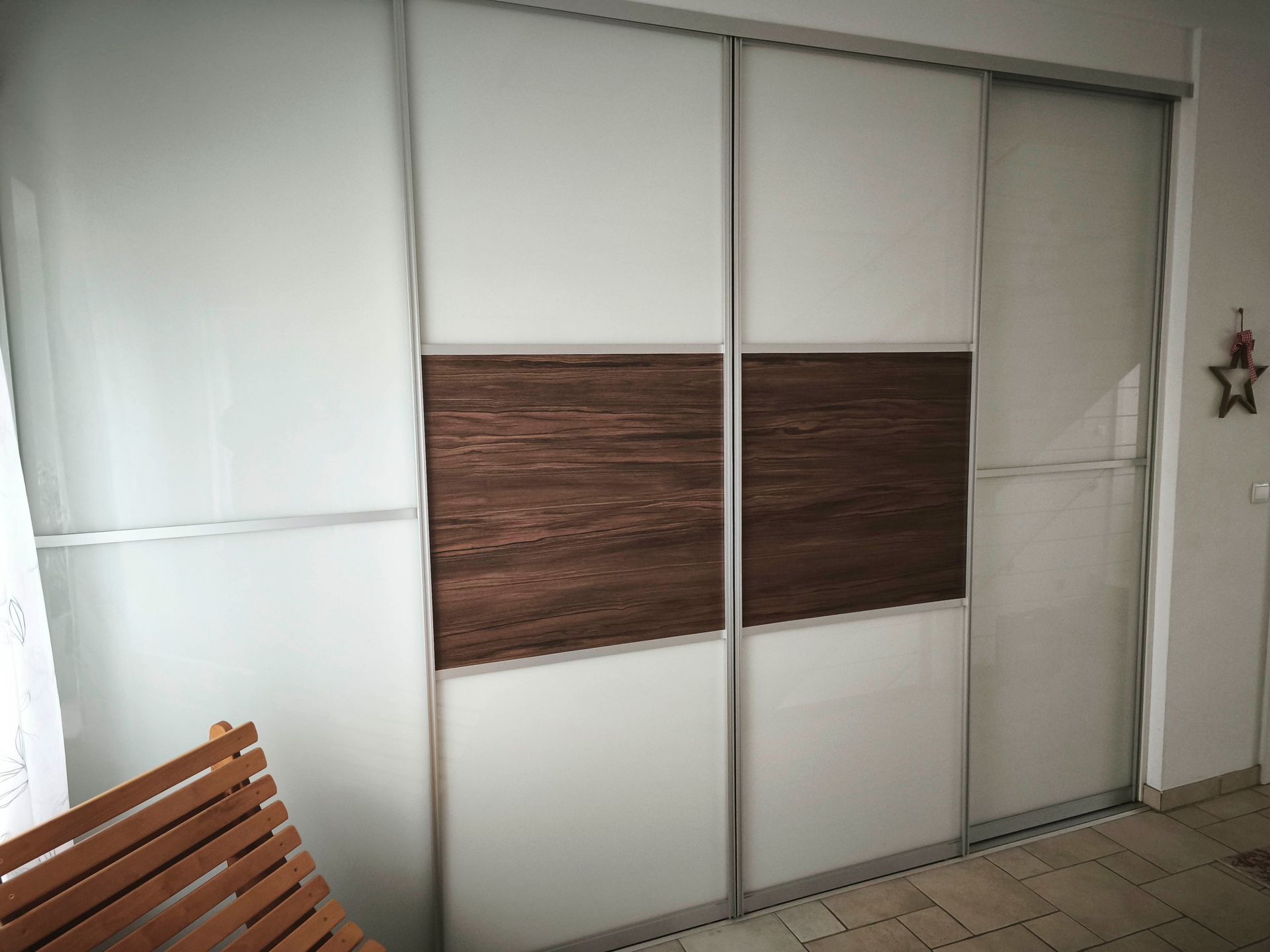 Eine Glasschiebetür mit einer Holzplatte in einem Raum.