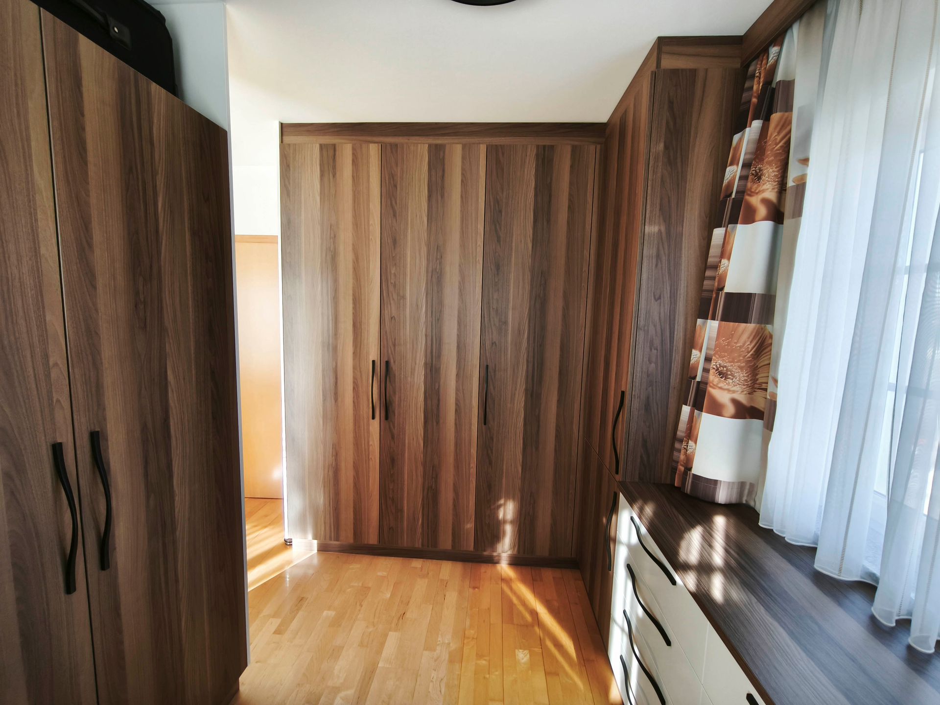 Ein Raum mit vielen Holzschränken und Vorhängen