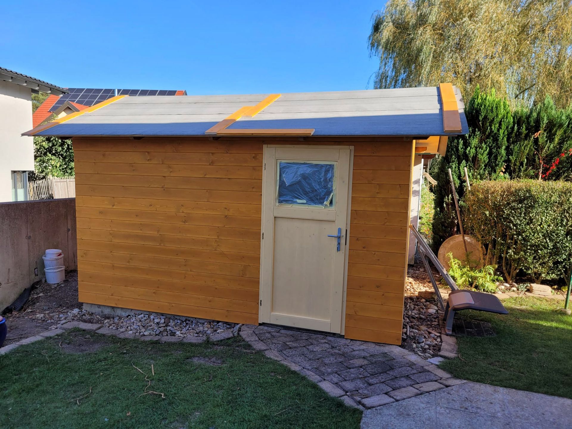 In einem Hinterhof wird ein Holzschuppen gebaut.