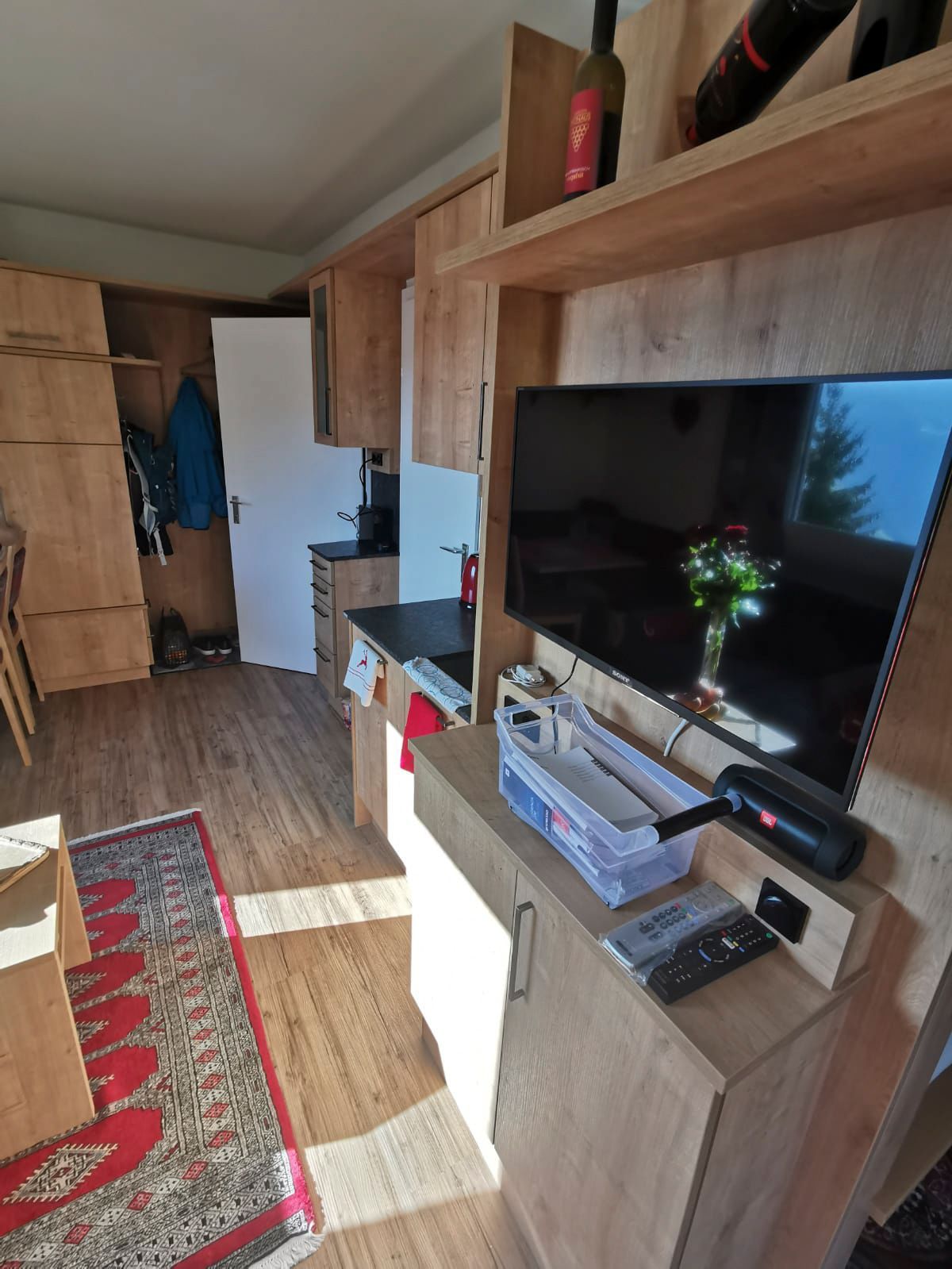 Ein Wohnzimmer mit einem Flachbildfernseher an der Wand.