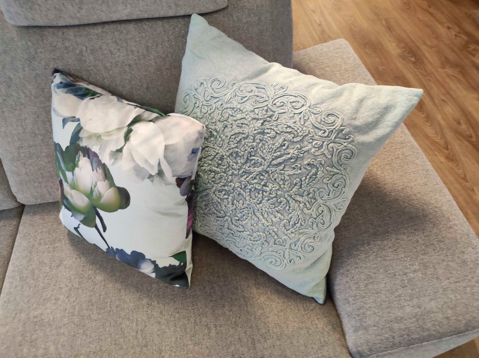 Zwei Kissen liegen nebeneinander auf einem Sofa
