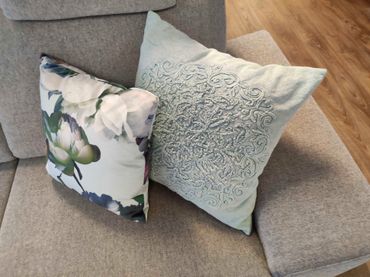 Zwei Kissen liegen nebeneinander auf einem Sofa
