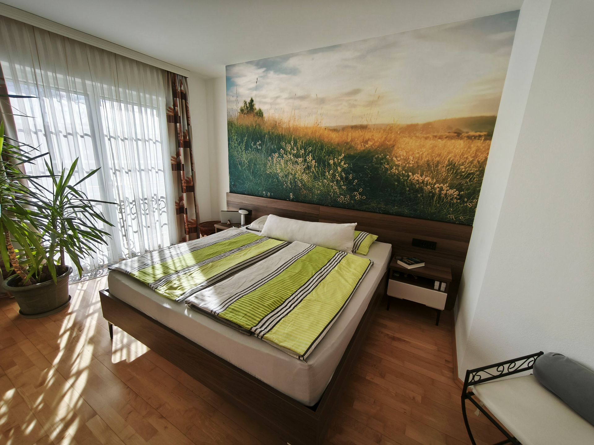 Ein Schlafzimmer mit einem großen Bild an der Wand über dem Bett