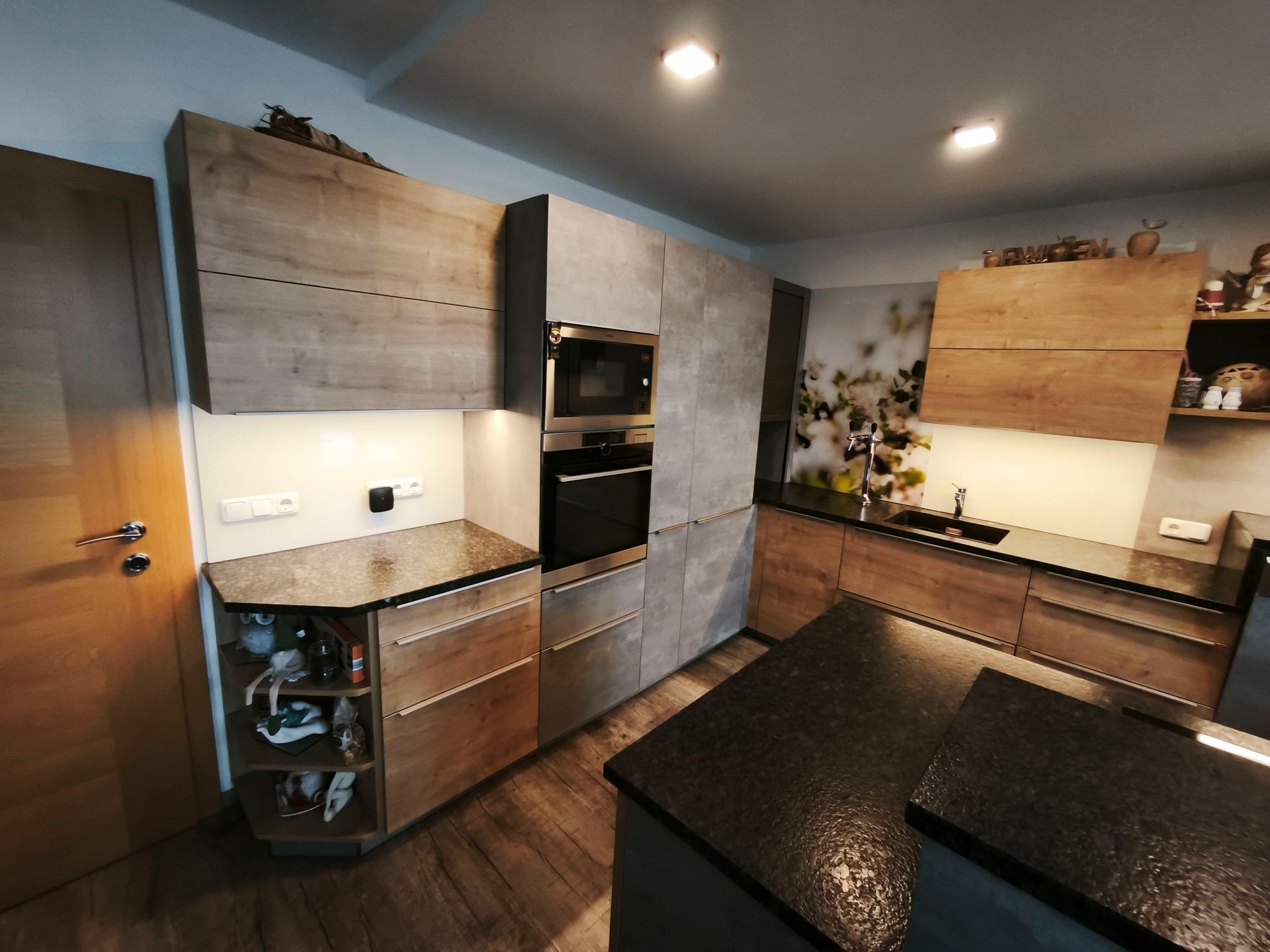 Eine Küche mit Holzschränken und schwarzen Arbeitsplatten