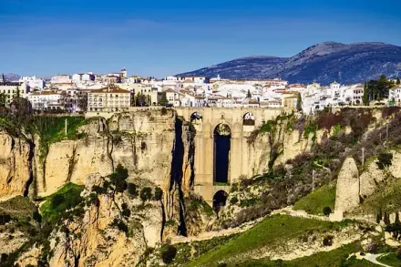 Una vista aérea de un puente sobre un acantilado con una ciudad al fondo.