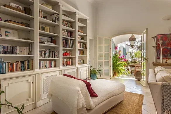 Una sala de estar con un sofá y una estantería llena de libros.