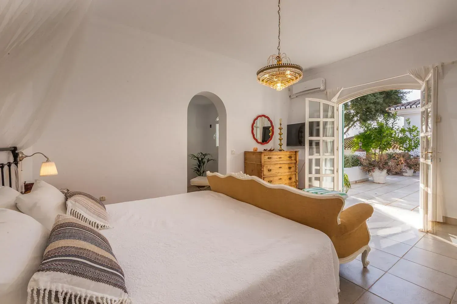 Un dormitorio con una cama king size y un sofá.