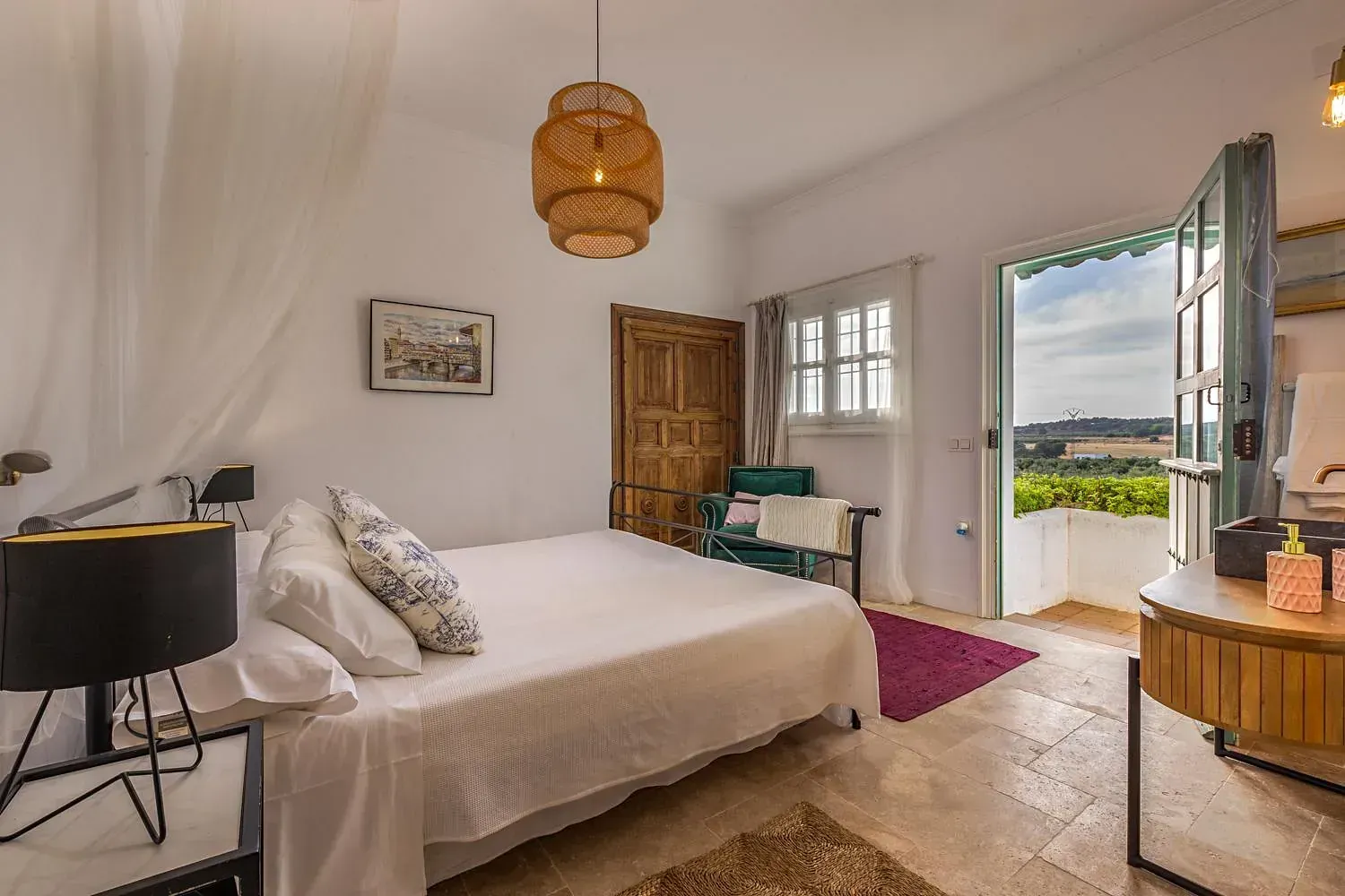Un dormitorio con una cama grande, una silla, un escritorio y una ventana.