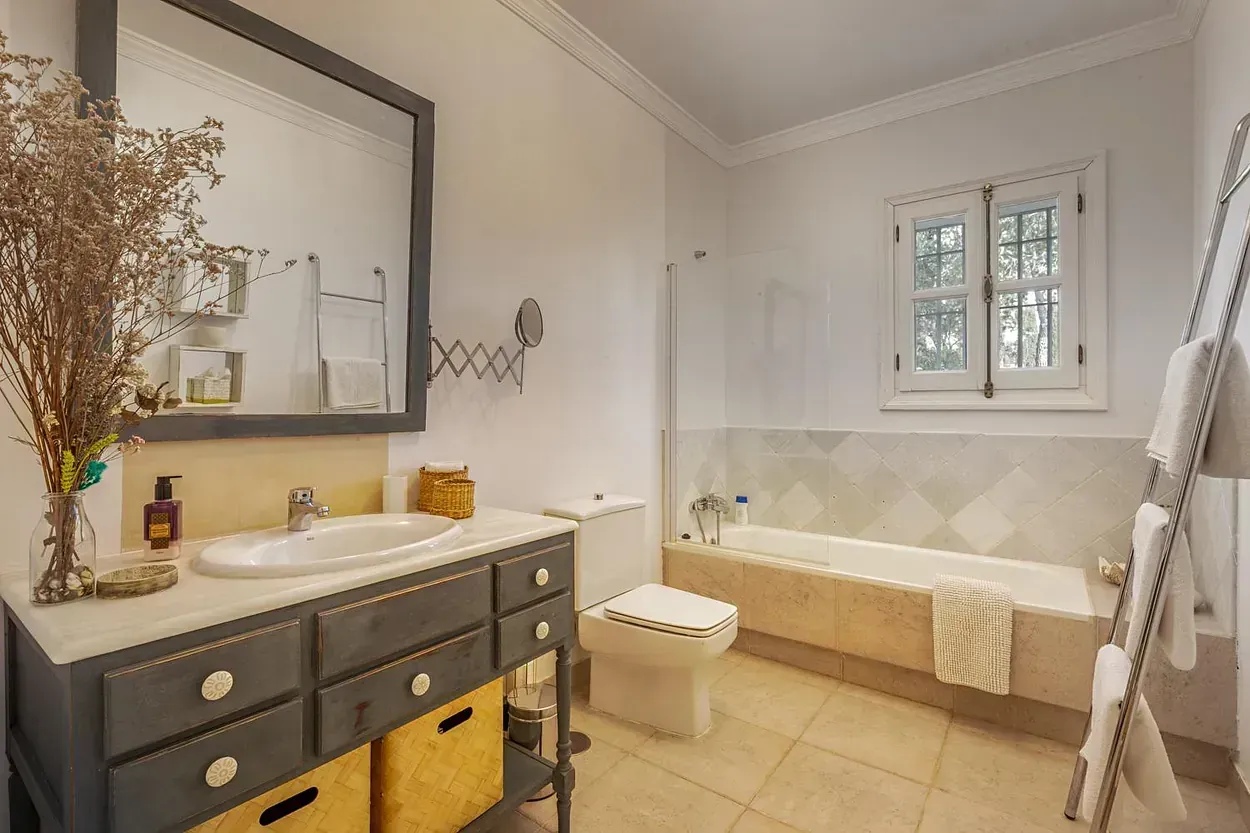 Un baño con lavabo, inodoro, bañera y espejo.