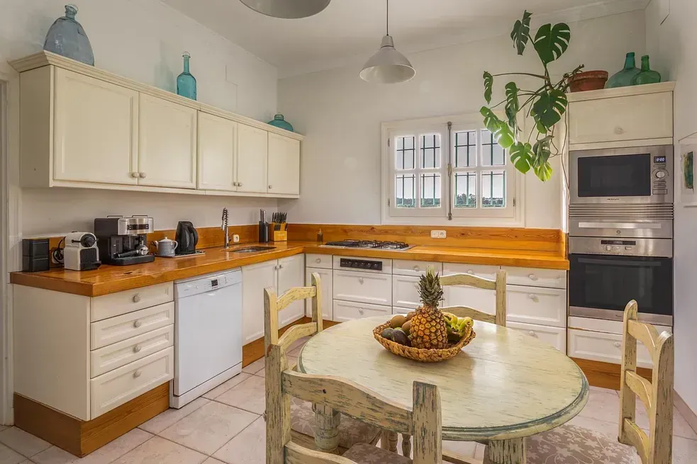 Una cocina con una mesa y sillas y una piña en la encimera.