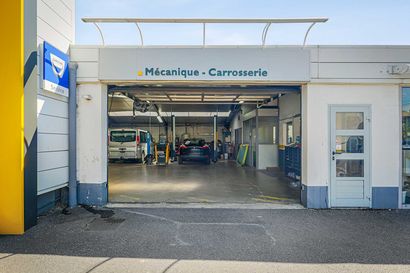 Garage Dacia avec baies ouvertes, laissant apparaître les véhicules à la lumière du jour.