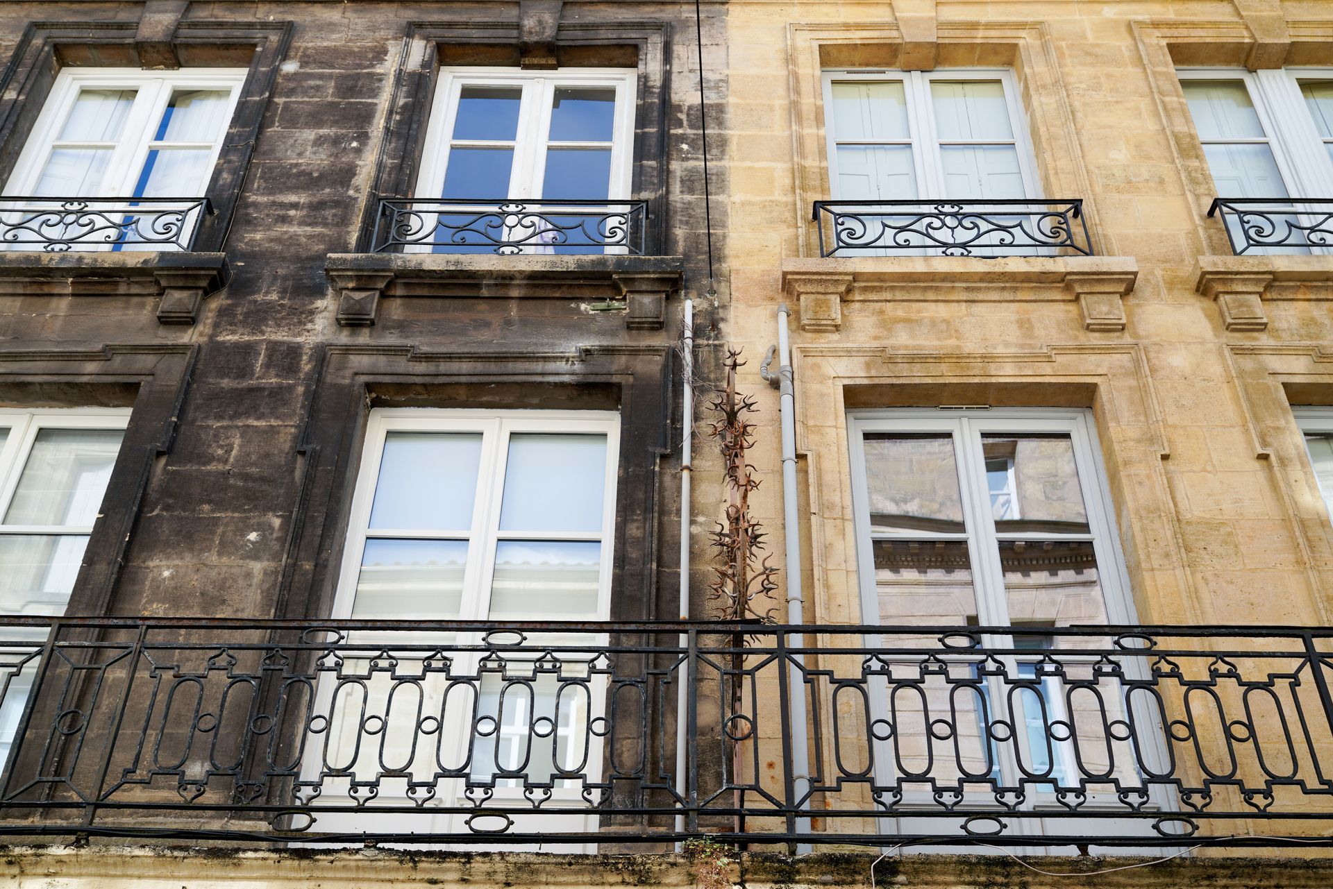 Contraste entre une façade tachée par la pollution et une façade nettoyée