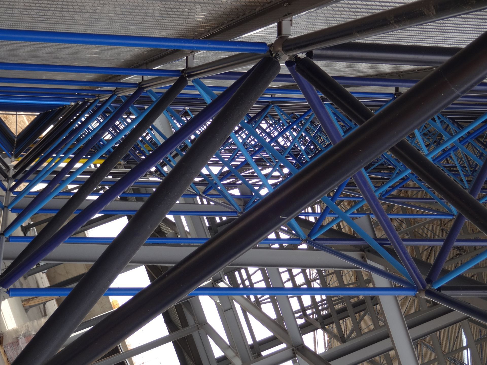 Una gran estructura espacial con vigas azules y negras.
