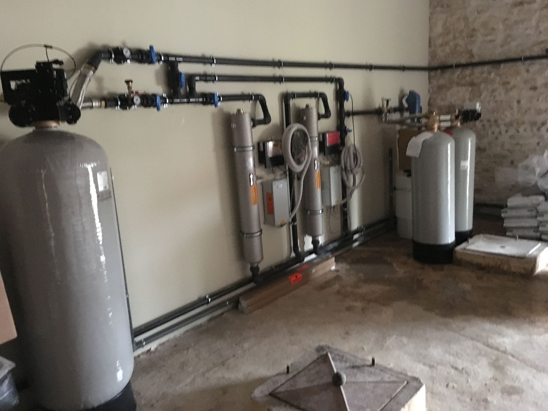 Local technique de piscine avec tuyaux, filtres et panneaux de contrôle.