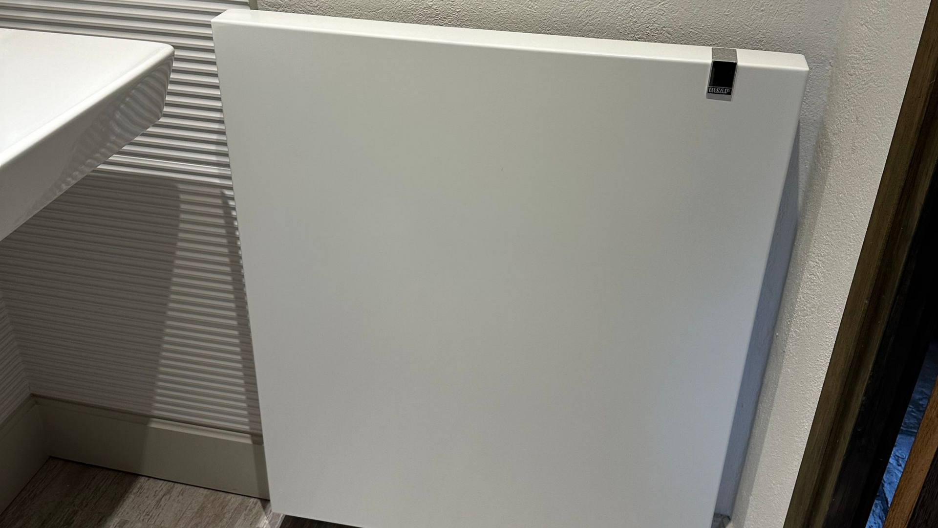 Main d'une personne tournant le robinet d'un radiateur.