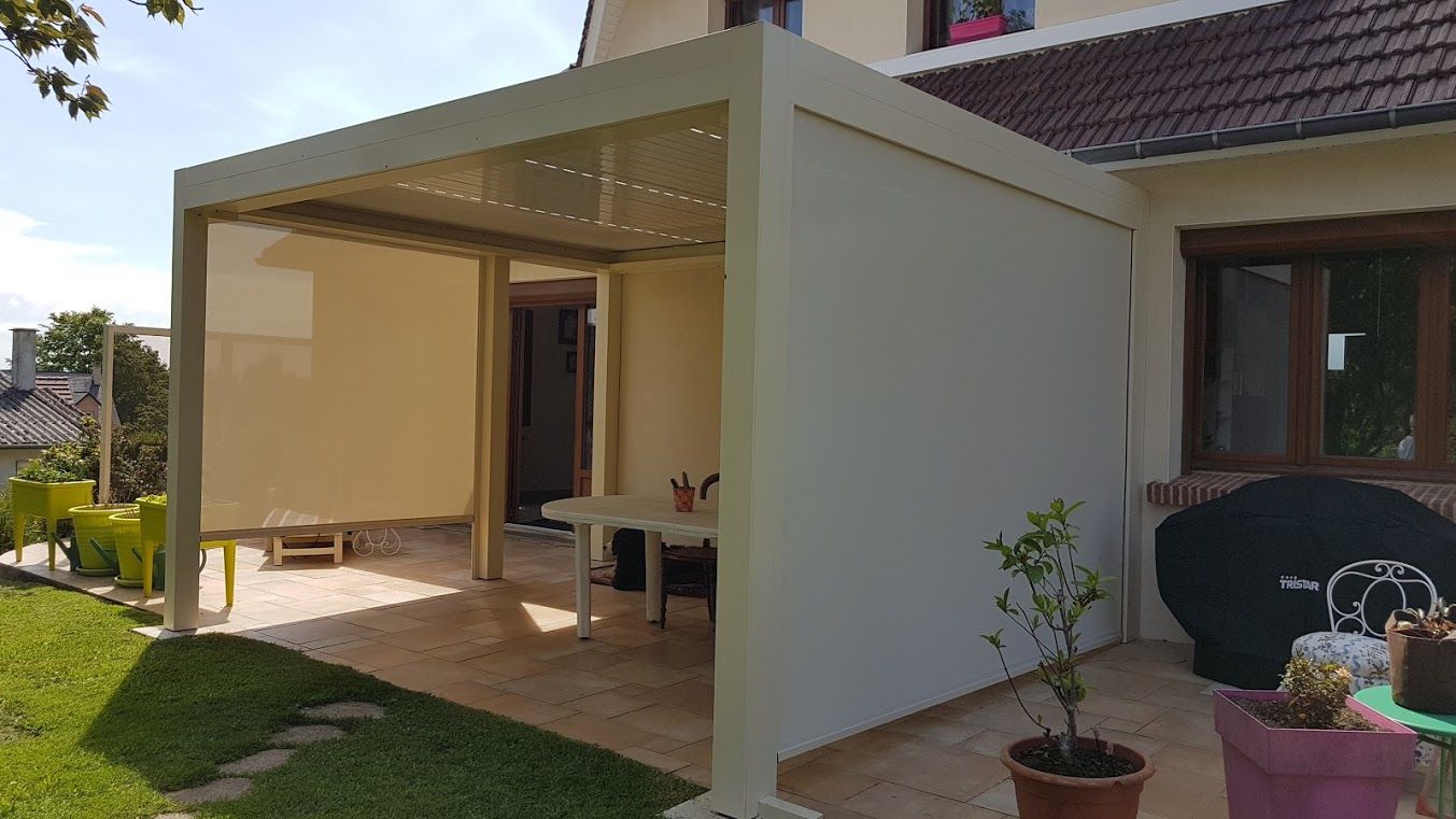 Une pergola blanche fermée sur la terrasse d'un jardin