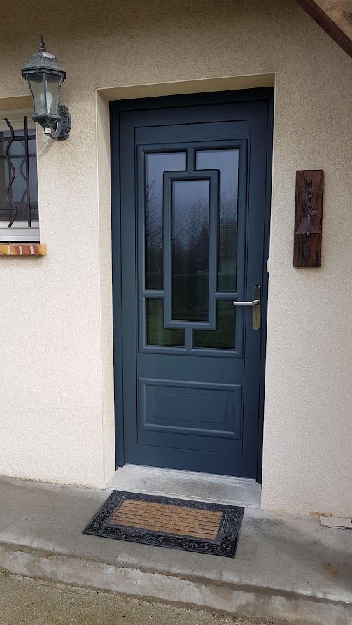 Une porte d'entrée avec des vitres de forme rectangulaire