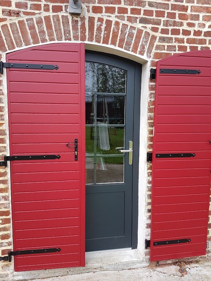 Une porte d'entrée avec des volets rouges