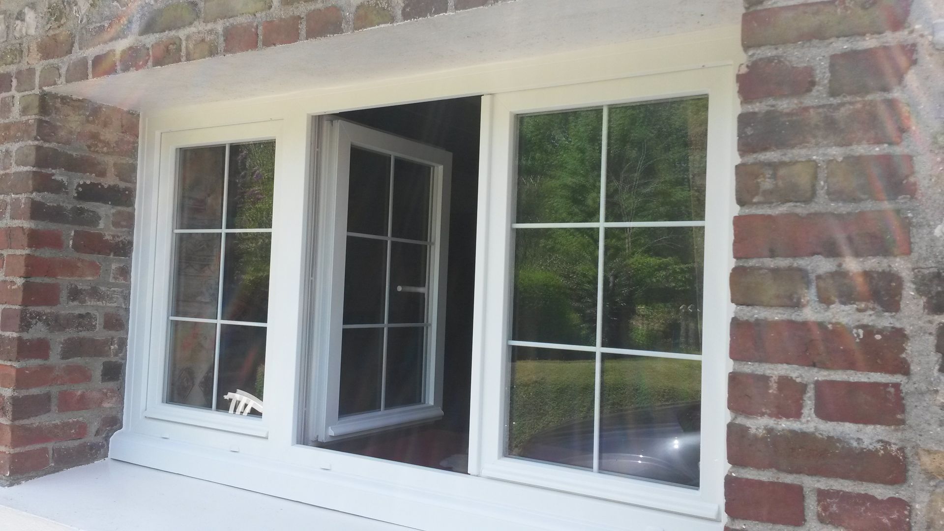 Une fenêtre blanche ouverte entre deux autres fenêtres blanches