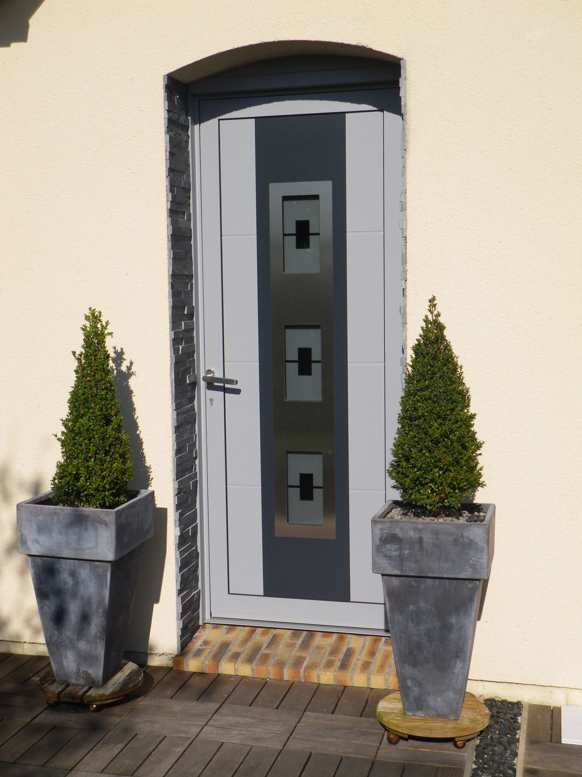 Porte d'entrée entourée de deux buis