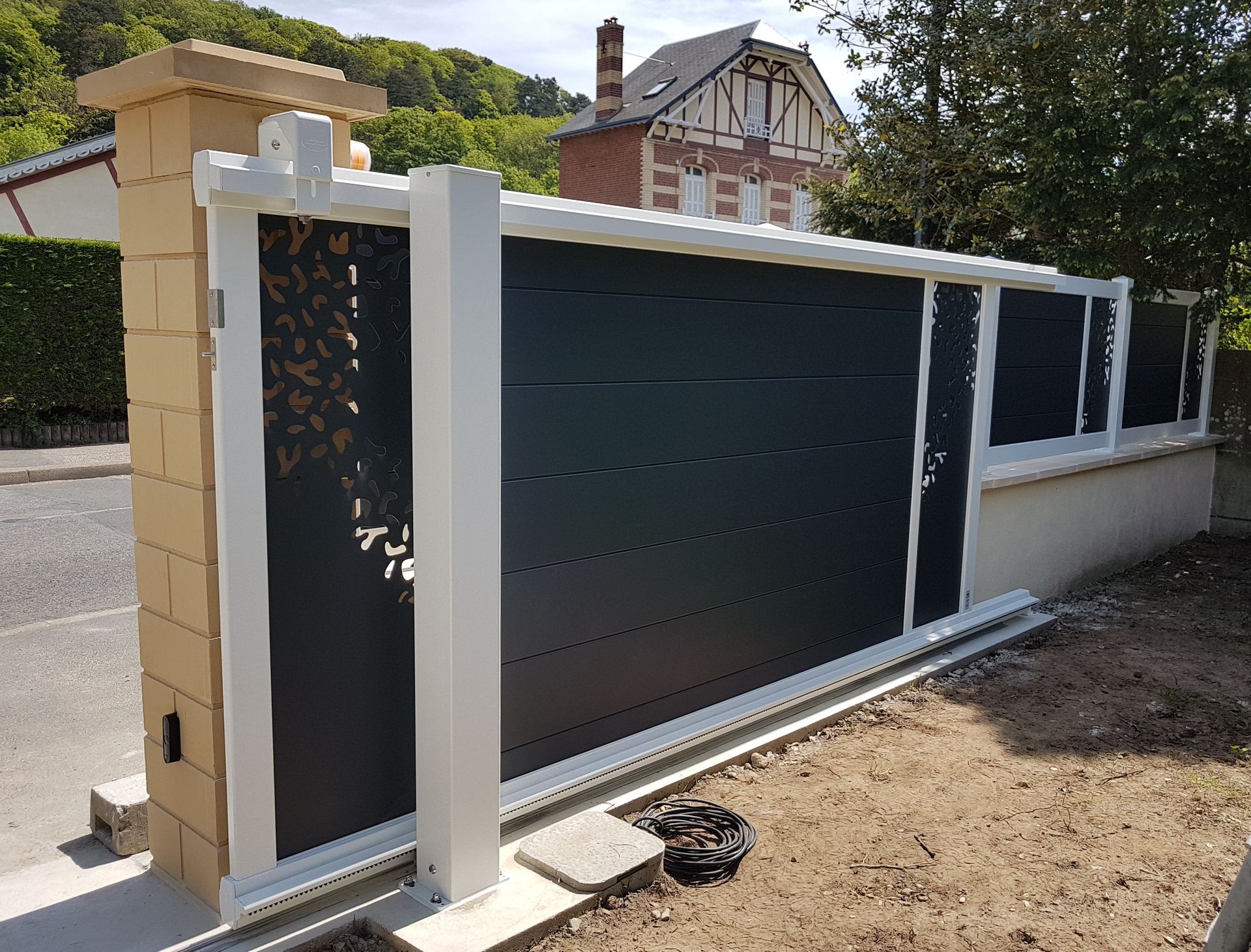 Portail gris à bordure blanche, coulissant et automatisé