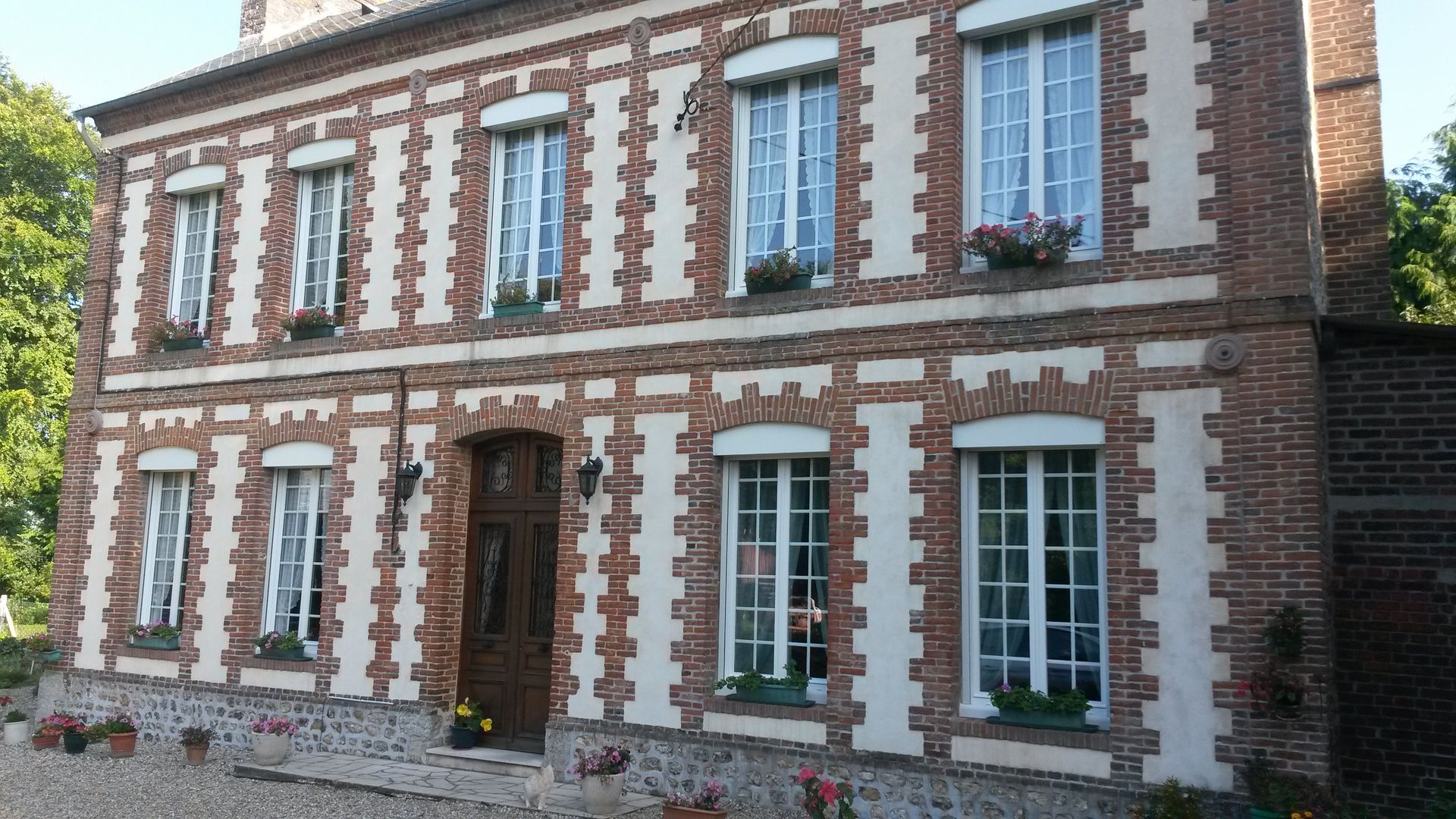 Une grande maison avec plusieurs fenêtres blanches
