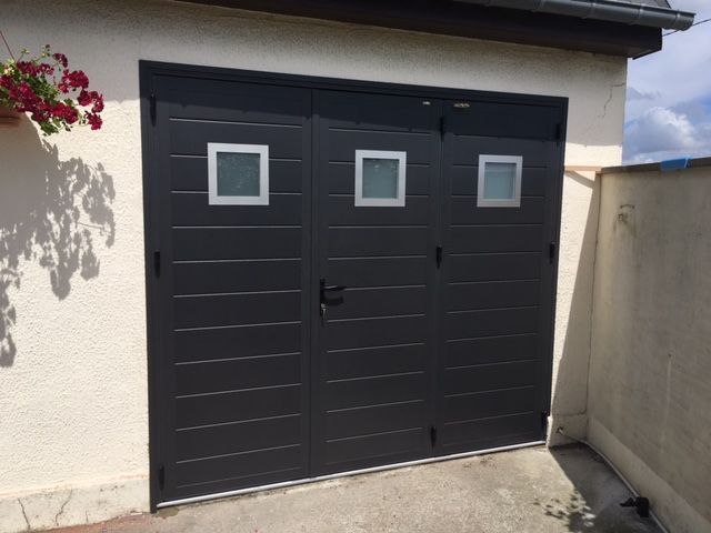 Une porte de garage noire avec une entrée centrale