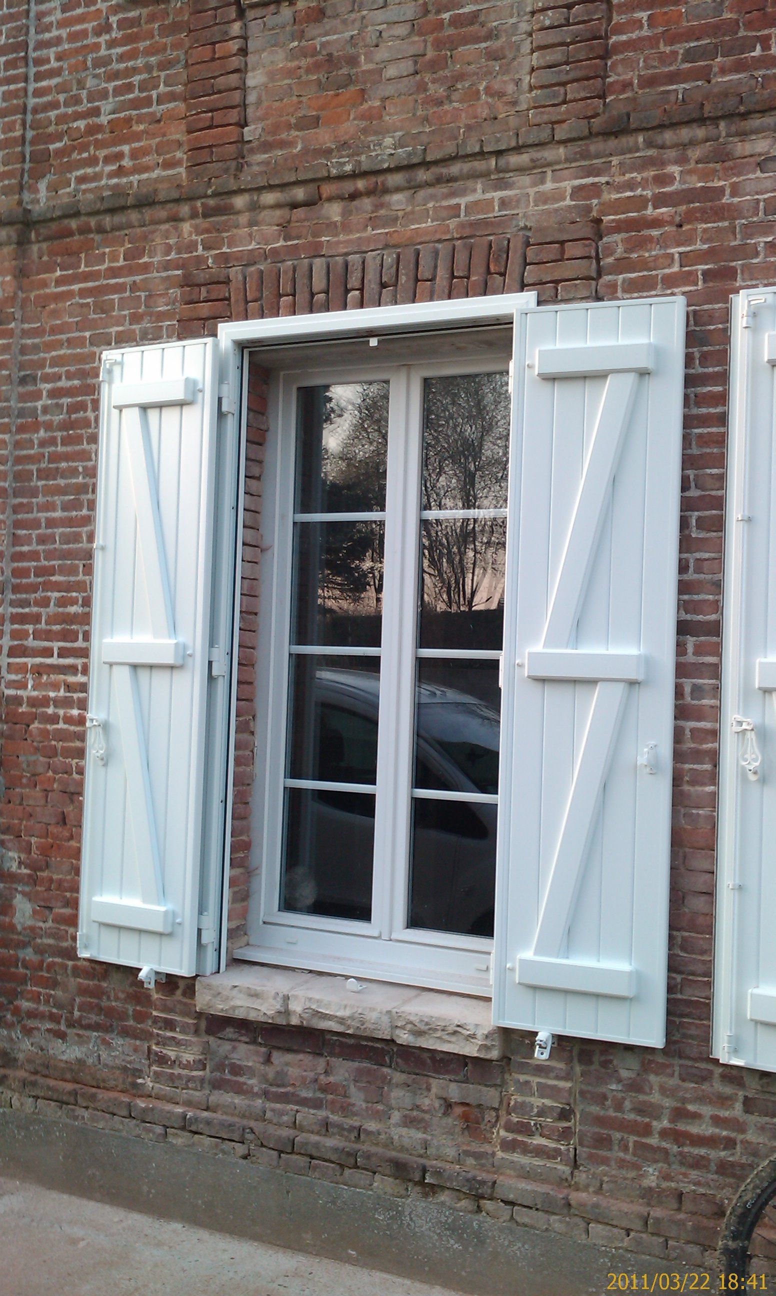 Une fenêtre avec des volets blancs